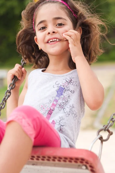 Menina encantadora em um balanço no parque — Fotografia de Stock