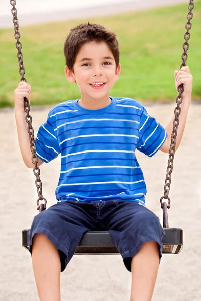 Mladý kluk líbí swing ride — Stock fotografie