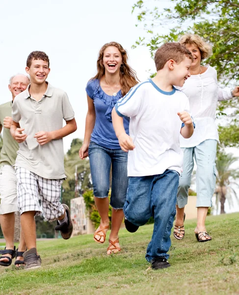 Familjen jagar ung grabb i parken — Stockfoto