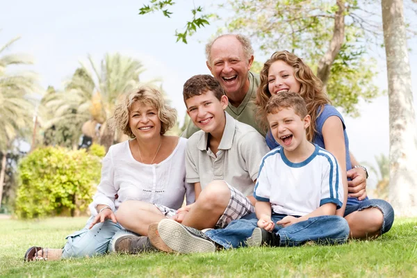 Szczęśliwa rodzina bawiąca się w parku — Zdjęcie stockowe