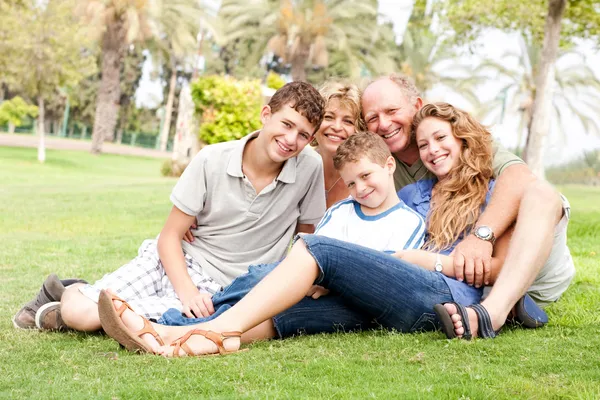 Lycklig familj avkopplande i parken — Stockfoto