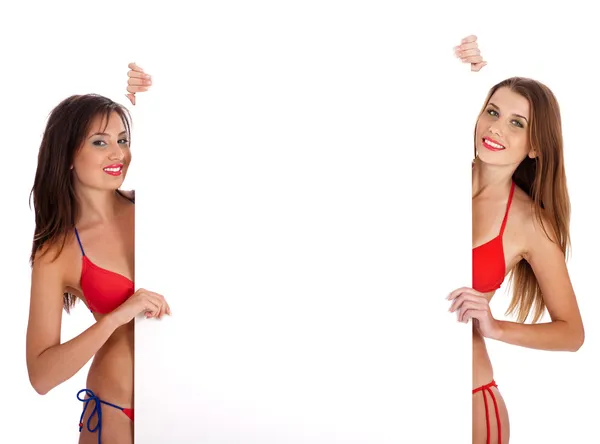 Tjejer i bikini hålla en tecken styrelse — Stockfoto