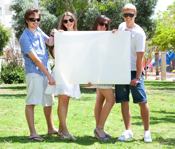 Adolescentes con cartelera blanca de pie en el parque —  Fotos de Stock