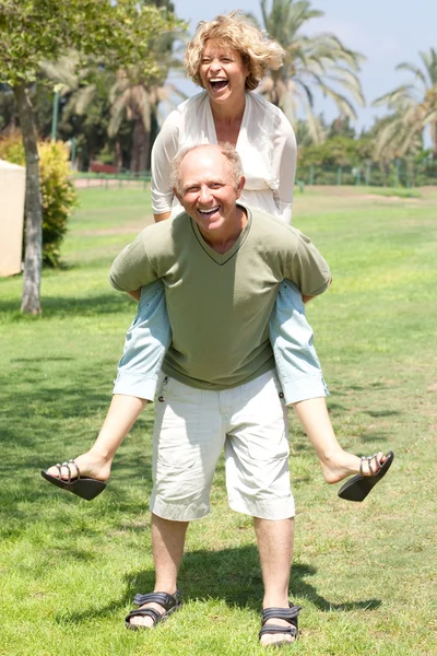 Εικόνα του ανώτερος άνθρωπος δίνοντας γυναίκα piggyback βόλτα — Φωτογραφία Αρχείου