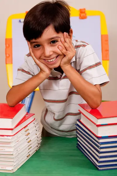 Netter kleiner Junge ruht sich auf Büchern aus — Stockfoto