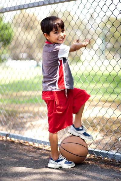 Niño inteligente posando con baloncesto —  Fotos de Stock