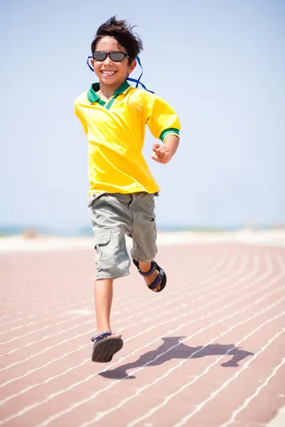 Jeune enfant en course sur piste de course — Photo