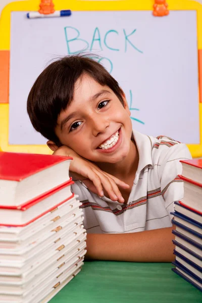Jeune garçon avec pile de livres — Photo