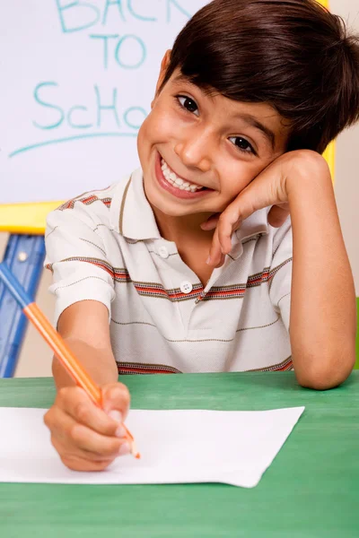 Portret wesoły chłopiec pisanie notatek — Zdjęcie stockowe