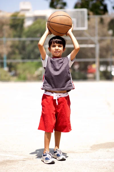 Młody chłopak gotowy do strzału koszykówki — Zdjęcie stockowe