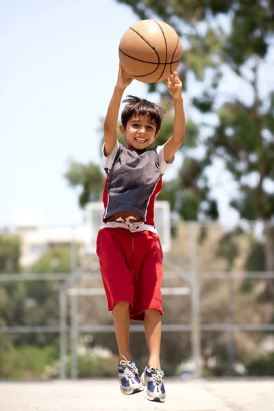 Jovem jogador de basquete pulando alto — Fotografia de Stock
