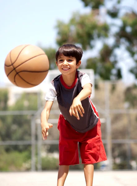 Jovem menino passando basquete — Fotografia de Stock