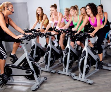 Group of doing exercise on a bike clipart