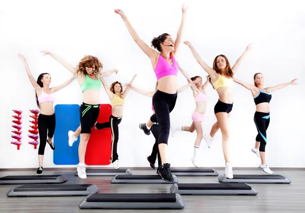 Grupp kvinnor gör aerobics på stepper — Stockfoto