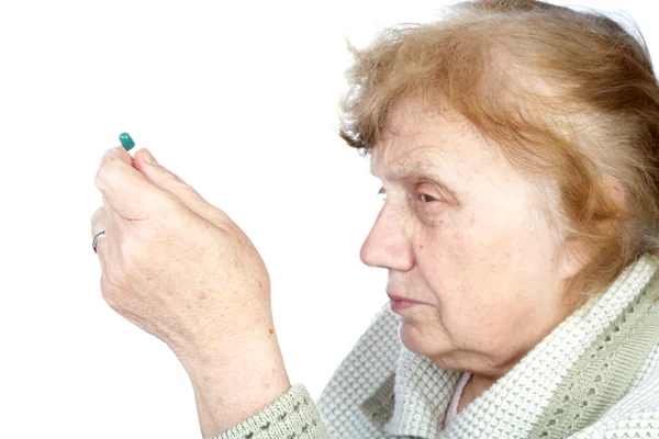 De oude vrouw houdt in handen capsule — Stockfoto