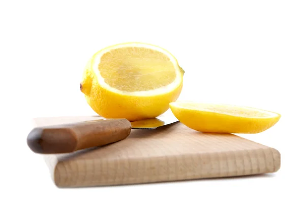 Cuchillo y el limón cortado en una tabla de cortar aislado — Foto de Stock