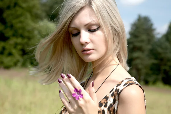 The thoughtful girl with a field flower — Stock Photo, Image