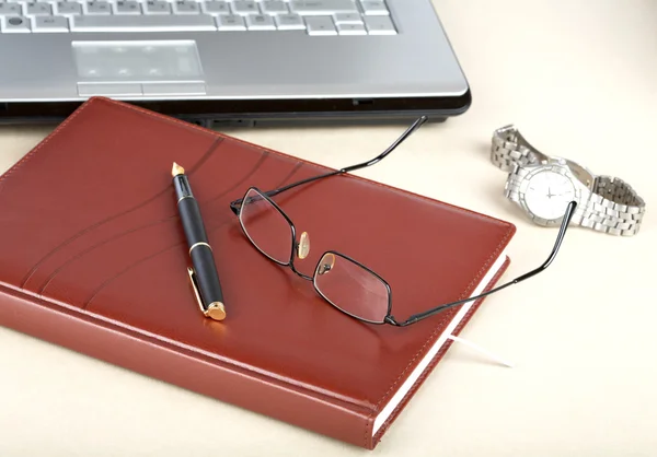 Den bärbara datorn en arrangör en penna och klocka — Stockfoto