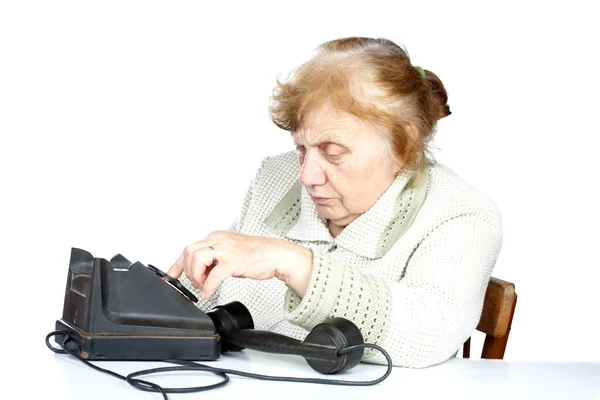 Den gamla kvinnan ringer upp nummer i telefonen — Stockfoto