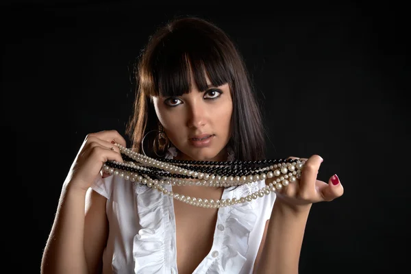 Zamyšlená dívka s perlově korálky v ruce — Stock fotografie