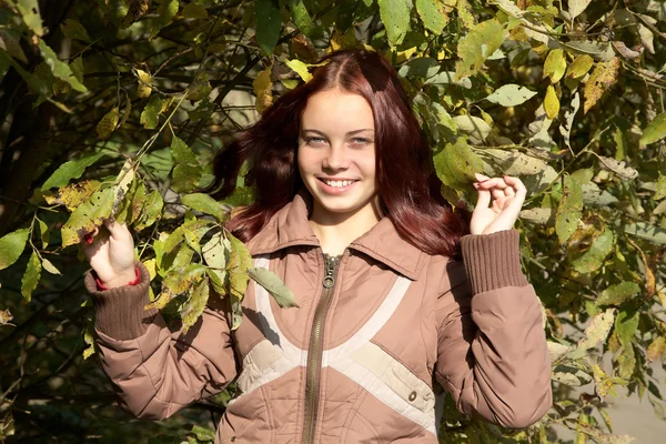 Bir ağaç karşı gülümseyen kız — Stok fotoğraf
