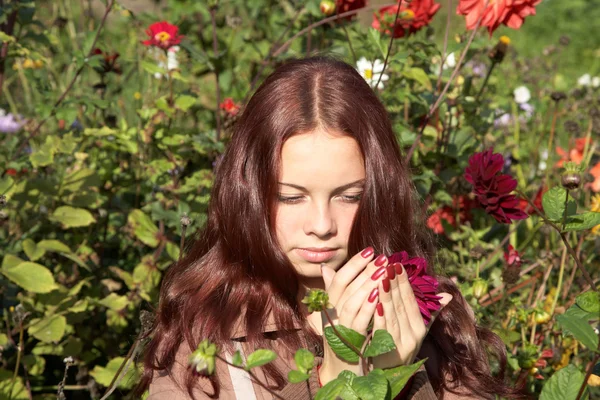 Das Mädchen nimmt eine Blume in die Hand — Stockfoto