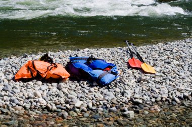 Two life-jackets and two paddles clipart