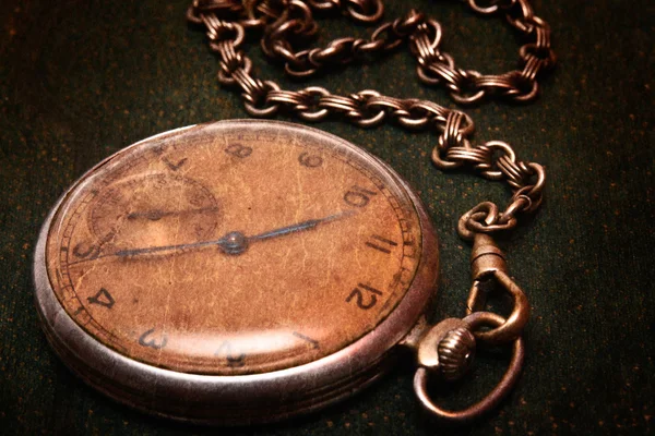 Reloj viejo con cadena que miente en la superficie verde áspera —  Fotos de Stock