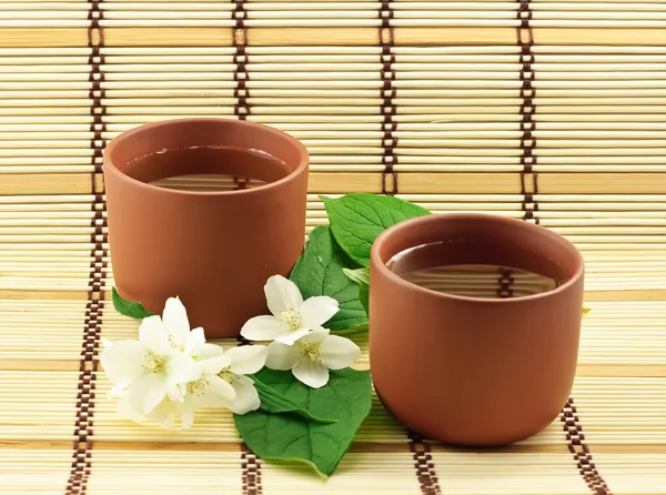 Fresh green tea with jasmin white flowers