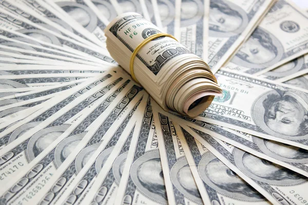 Tăierea banilor rulați pe un fond de dolari — Fotografie, imagine de stoc