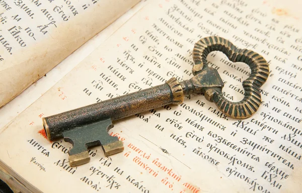 Fechar a chave colocada na bíblia vintage — Fotografia de Stock