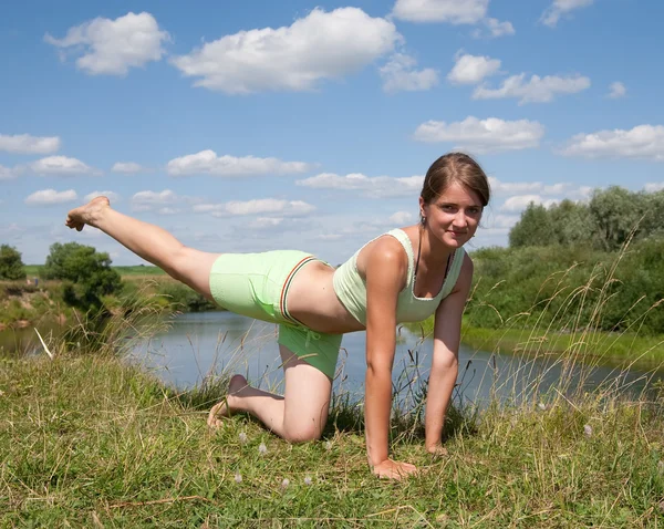 Menina desportiva se exercitando contra o rio — Fotografia de Stock