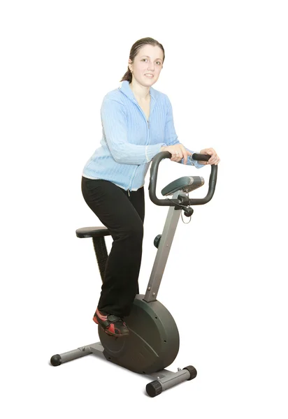 Girl workout on stationary bicycle — Stock Photo, Image