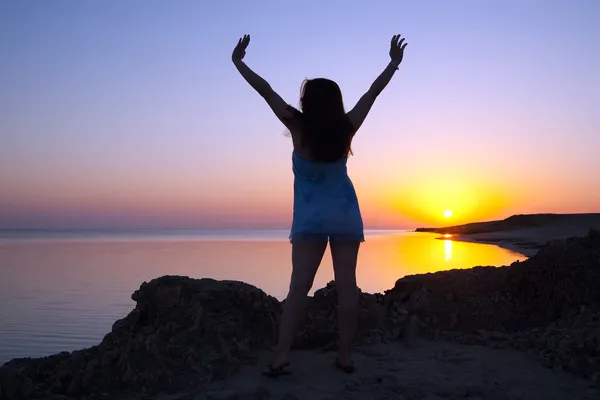 Девушка на побережье моря во время восхода солнца — стоковое фото