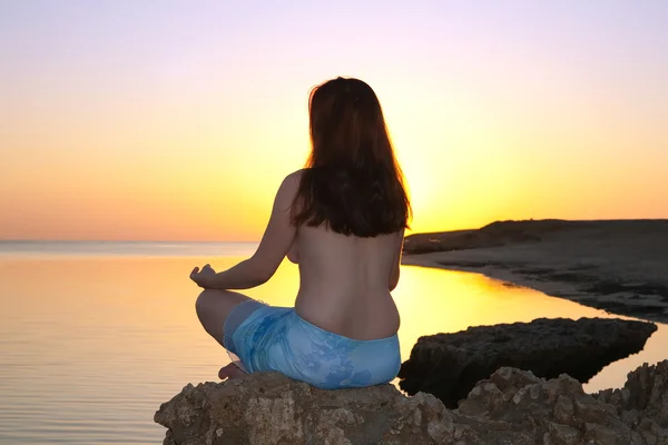 Girl practicing yoga against sunset — Stock Photo, Image