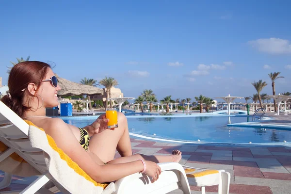 Chica con jugo de naranja en el hotel resort —  Fotos de Stock