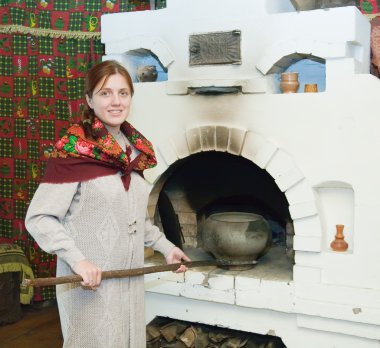 Woman puts a pot into russian stove clipart