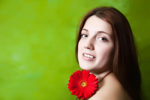 Κορίτσι με το κόκκινο λουλούδι πέρα από το πράσινο — Φωτογραφία Αρχείου