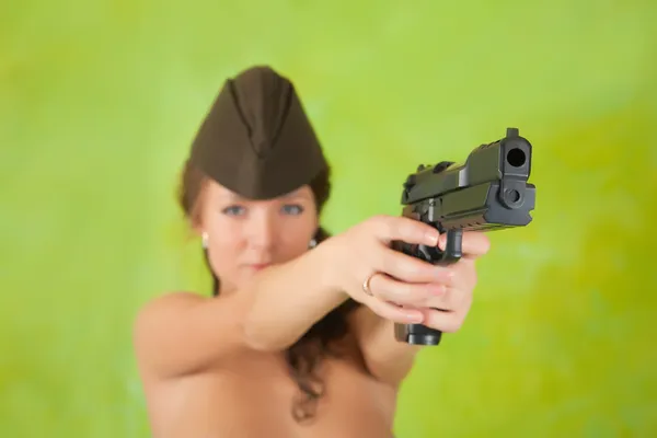 Chica apuntando un arma negra — Foto de Stock