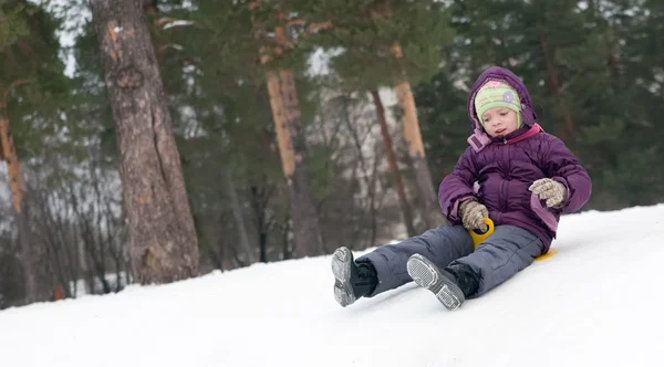 Criança deslizando na neve — Fotografia de Stock
