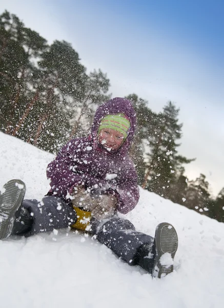 Kind in de sneeuw glijden — Stockfoto
