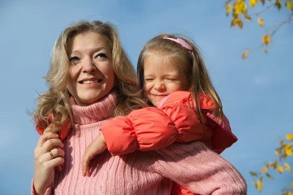 Glad mamma med dotter mot himlen — Stockfoto