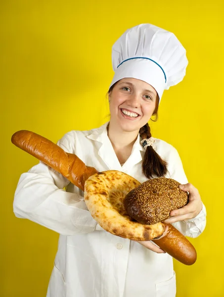 Пекарь с руками, полными хлеба — стоковое фото