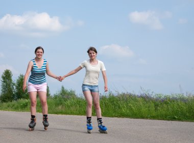 Two Young girls on roller blades clipart