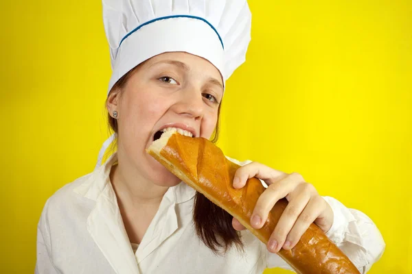 Woman is eating french bread — Stock Photo, Image