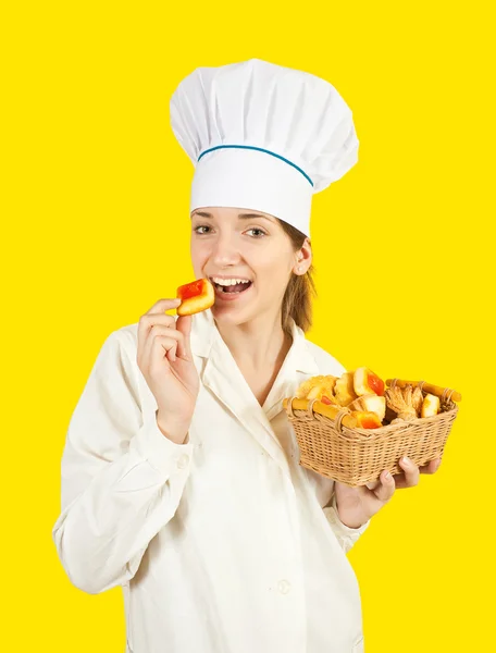 Cook eating tasty cookie — Stock Photo, Image