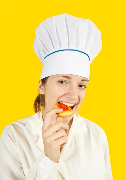 Female cook eating cookie — Stock Photo, Image