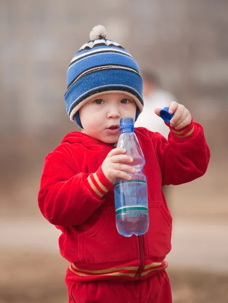 Malý chlapec drží láhev — Stock fotografie