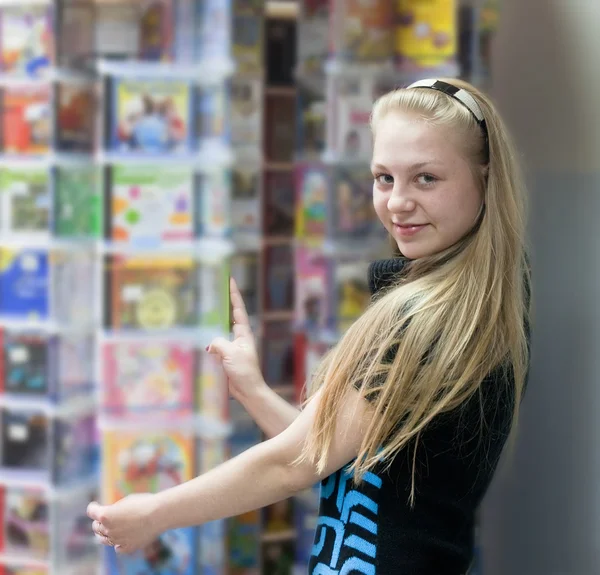 Dziewczyna w sklepie wybiera dysku — Zdjęcie stockowe