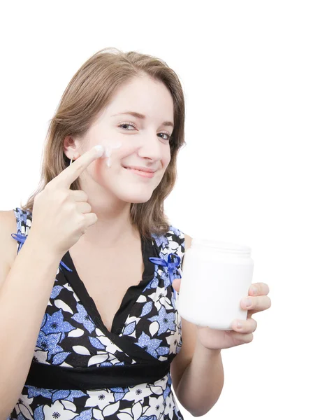 Meisje invoering crème op haar gezicht — Stockfoto